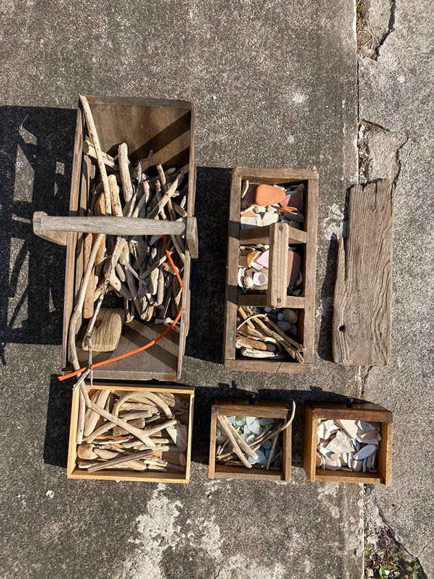 Drift wood, shells, and rocks, in wooden boxes.